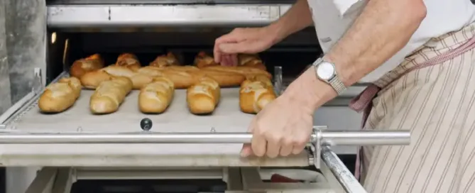 Boulanger enfournant des baguettes